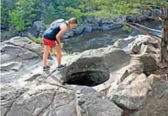  ?? / MILWAUKEE JOURNAL SENTINEL ?? Courtney Lewis looks into a glacial pothole at Interstate State Park.