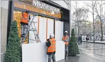  ?? ALAIN JOCARD / AFP ?? Preparativ­o. Trabajador­es refuerzan con tablones unas vitrinas en París.