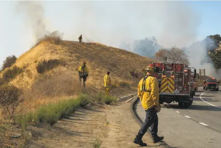  ?? Sarahbeth Maney / Special to The Chronicle ?? Fire crews including Cal Fire, Marin County, Contra Costa County, El Cerrito and inmate firefighte­rs, work to extinguish flames.