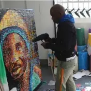  ?? DENIS FARRELL/THE ASSOCIATED PRESS ?? Using a heat gun, South African artist Mbongeni Buthelezi works on a portrait in his Johannesbu­rg studio.