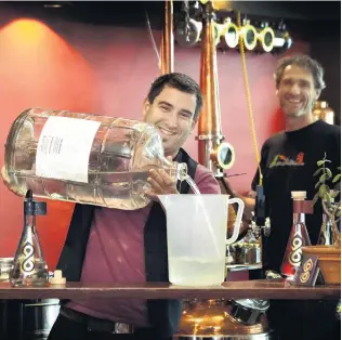  ?? PHOTO: PETER MCINTOSH ?? Watching you . . . Julien Delavoie (left) and Michael Wilson in the No8 Distillery in the window of Dog With Two Tails in Dunedin.