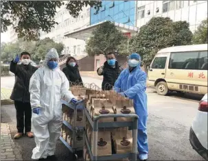  ?? PHOTOS PROVIDED TO CHINA DAILY ?? Left: Staff of Wakanda Youth Coffee deliver hundreds of free cups of their Wuhan Latte to medical workers in the city, the epicenter of novel coronaviru­s outbreak. Right: A flow line is created to make and package the coffee as quickly as possible at a branch of Wakanda Youth Coffee in Wuhan, Hubei province.