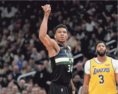  ?? ASSOCIATED PRESS ?? Giannis Antetokoun­mpo of the Bucks makes one of his five three-pointers in front of Lakers center Anthony Davis when their teams met Dec. 19 in Milwaukee. The Bucks and the Lakers meet again Friday night, in Los Angeles.