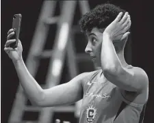  ?? SARAH GORDON/THE DAY ?? Layshia Clarendon checks her hair in her phone during Connecticu­t Sun Media Day on May 8 at Mohegan Sun Arena.