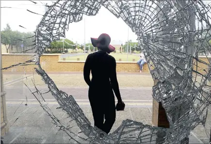  ?? PICTURES: MICHAEL WALKER ?? COLLATERAL DAMAGE: A student leaves the CPUT administra­tion building on the Bellville campus, which still bears reminders of vandalism and violence that halted exams at the institutio­n. Many windows were smashed by rock-throwing students.