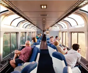  ?? KEVIN MIYAZAKI/THE NEW YORK TIMES ?? Passengers on the California Zephyr Amtrak train take in the Iowa landscape from the observatio­n car, in September last year.