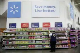  ?? JULIO CORTEZ — THE ASSOCIATED PRESS FILE ?? Walmart employee Kenneth White scans items while conducting an exercise during a Walmart Academy class session at the store in North Bergen, N.J. Walmart reported financial results Tuesday.