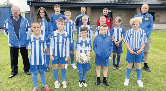  ??  ?? Pitch progress Blairgowri­e and Rattray Community Football Club players and coaches with Sandy Thomson, left, and chair Eck Petrie. Pic: Clare Damodaran