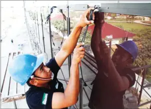  ?? VIREAK MAI ?? A worker at Star8 solar factory in Phnom Penh installs solar panels in 2014.