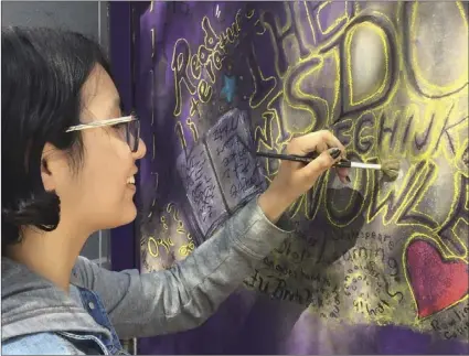  ?? HOOD PHOTO ?? Southwest art student Denise Cruz paints a mural on a teacher’s door at Southwest High School. AJA