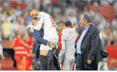  ?? ?? En-Nesyri se abraza a Monchi ante Jesús Gomez, director de comunicaci­ón, al término del Sevilla-Manchester.