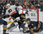  ?? JEFFREY T. BARNES - AP ?? Philadelph­ia Flyers forward Scott Laughton (21) collides with Buffalo Sabres goalie Robin Lehner (40) during the second period Friday in Buffalo, N.Y.