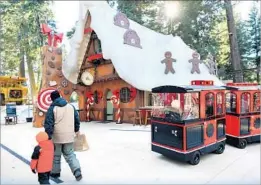  ?? Wally Skalij Los Angeles Times ?? A TRAIN passes the Gingerbrea­d House bakery at Santa’s Village on opening day Friday. The park south of Lake Arrowhead reopened after nearly 20 years.