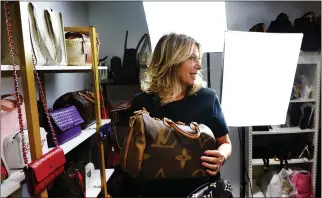  ?? NOAH K. MURRAY — ASSOCIATED PRESS ?? Deborah Mayer holds one of the luxury handbags she sells on TikTok on March 21in Freehold, N.J. A bill to ban TikTok could be law as soon as next week if Congress moves quickly.