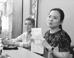  ??  ?? Lau (right) shows the police report. At left is the taxi driver.