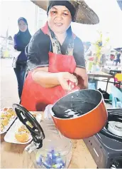  ??  ?? Emily pours boiled water into the pot to make telang tea.