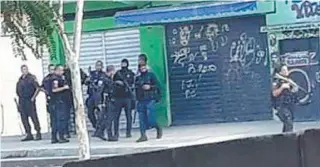  ?? REPRODUÇÃO ?? Homens com toucas ninjas e fuzis, que seriam milicianos, se misturam com PMs fardados na Cesário de Melo