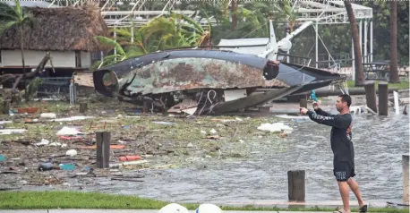  ?? JACK GRUBER/USA TODAY ?? Destroyed sail boats sit in the marina across from Miami City Hall on Sunday as people venture out while the last major bands of wind and rain of Hurricane Irma pass over Miami.