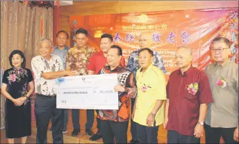  ?? ?? Nanta (fourth right) presents a mock cheque for RM500,000 to Penghulu Shia Shui Poh, the associatio­n’s advisor. Seen behind them, on the platform, are (from right) Ambrose, Nicholas, Cerisologo and James.