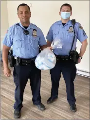  ??  ?? Pottstown Police officer Steve Dise, left, and Cpl. Todd Istenes with masks donated by The Hill School.