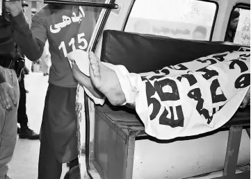  ??  ?? Ambulance workers load the body of Mashal Khan into an ambulance after a mob beat him to death at his university campus in Mardan, Pakistan. — Reuters photo