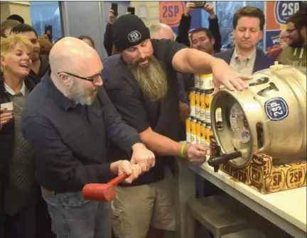  ?? PHOTOS BY PETE BANNAN — DIGITAL FIRST MEDIA ?? Wawa Product Developmen­t Manager Michael McLaughlin and 2SP head brewer Bob Barrar tap the Wawa Winter Reserve Coffee Stout Thursday at the convenienc­e store chain’s Chadds Ford location.