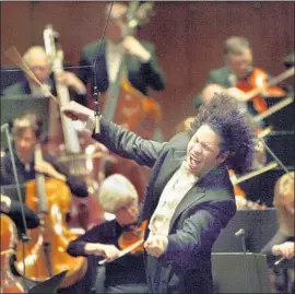  ?? Carolyn Cole Los Angeles Times ?? GUSTAVO DUDAMEL lets it all out while leading the New York Philharmon­ic in 2007. Recordings of the orchestra are among those available on streaming service.