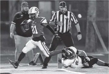  ?? DANIEL A. VARELA dvarela@miamiheral­d.com ?? Miami Central wide receiver Corey Washington scores on a 30-yard pass from Keyone Jenkins during the first quarter of the Rockets’ victory over Baker County in a 5A semifinals game on Friday at Traz Powell Stadium in Miami.