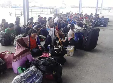  ??  ?? Caught: The group of illegal immigrants detained at the Port Klang Marine Police base after their boat was intercepte­d in Sabak Bernam.