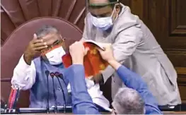  ?? — PTI ?? Trinamul Congress MP Derek O’Brien attempts to tear the rulebook as a ruckus erupts in the Rajya Sabha over agricultur­e- related bills during the ongoing Monsoon Session at Parliament House in New Delhi on Sunday.