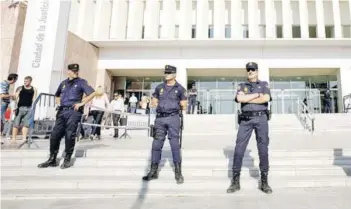  ??  ?? Policías montan guardia frente a la Ciudad de la Justicia de Málaga.