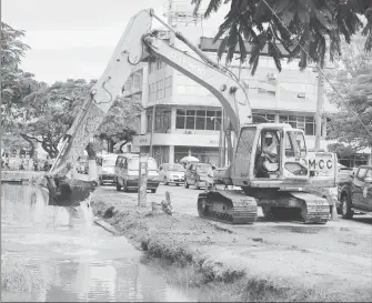  ??  ?? The city council dredging the Avenue of the Republic canal yesterday. (Terrence Thompson photo)