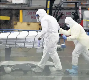  ?? PHOTO D’ARCHIVES, AFP ?? Le personnel médical déplace un patient décédé de la COVID-19 dans un camion frigorifiq­ue servant de morgue de fortune au Brooklyn Hospital Center de New York.