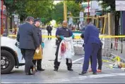  ?? Michael Perez Associated Press ?? POLICE investigat­ors on Sunday work the scene of a fatal shooting along South Street in Philadelph­ia.