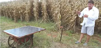  ??  ?? Lodie Steyl explains the solar-powered electric fence that keeps cattle within grazing strips