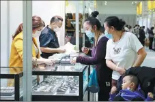  ?? WANG ZHENDONG / FOR CHINA DAILY ?? Visitors buy jewelry at the 13th China-Northeast Asia Expo, which is being held in Changchun, Jilin province.