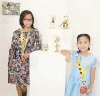  ??  ?? Young sculptors Santina Brienne, 9, daughter of Nixxio Castrillo, and Alessandra Gianina, 10, daughter of Mierro Castrillo, will make their grandfathe­r proud with their art pieces: Santina’s “Gertrude the Giraffe,” (left) and Alessandra’s “Flower Power” (right)