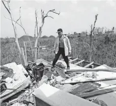  ?? GERALD HERBERT, AP ?? Jose Trinidad picks through what is left of his home in Montebello, Puerto Rico, where the vast majority of people are still without power.