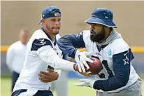  ?? AP Photo/Michael Owen Baker ?? n Dallas Cowboys quarterbac­k Dak Prescott, left, hands off to running back Ezekiel Elliott during practice Monday at the team's training camp in Oxnard, Calif.