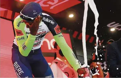  ?? Fotos: AFP ?? Ein Sektflasch­en-Malheur kostet Biniam Girmay die weitere Teilnahme am Giro d'Italia.