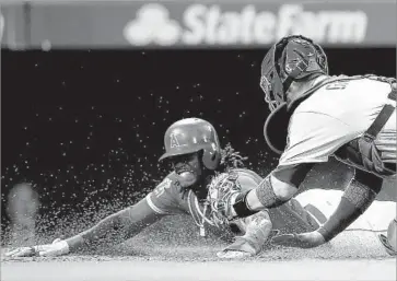  ?? Luis Sinco Los Angeles Times ?? CAMERON MAYBIN scores for the Angels in the fourth inning, beating Yasmani Grandal’s tag.