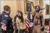  ?? MANUEL BALCE CENETA — THE ASSOCIATED PRESS FILE ?? Supporters of President Donald Trump, including Jacob Chansley, right with fur hat, are confronted by U.S. Capitol Police officers outside the Senate chamber inside the Capitol during the capitol riot in Washington.