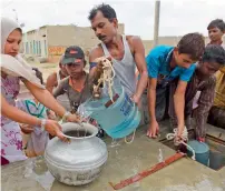  ?? AFP file ?? Residents fill containers with water provided by the government in a slum area of Karachi. —