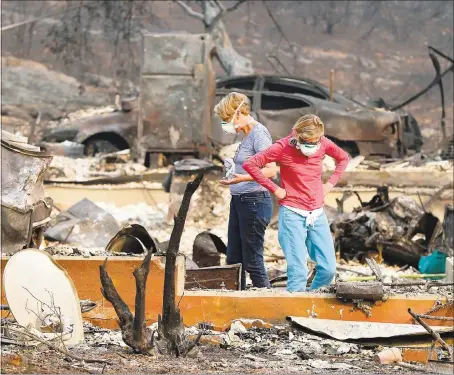  ?? RAY CHAVEZ — STAFF PHOTOGRAPH­ER ?? Two women sort through the rubble of the burned-out property in Napa where Sara and Charles Rippey died Sunday during the Atlas fire.