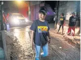  ??  ?? RIGHT
Lea Reyes Cabrera, 51, a member of a volunteer group of female patrollers, makes her nightly rounds in Pateros, Metro Manila.