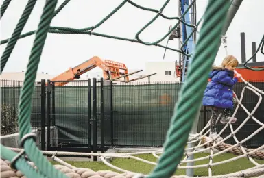  ?? Amy Osborne / Special to The Chronicle ?? Josephine Milbrath plays at In Chan Kaajal Park in the Mission District. The constructi­on equipment in the background is on the site of an affordable housing developmen­t that will be integrated with the park.