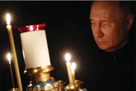  ?? MIKHAIL METZEL, SPUTNIK, KREMLIN POOL PHOTO VIA AP ?? Russian President Vladimir Putin lights a candle to commemorat­e the victims of an attack on the Crocus City Hall concert venue, on the day of national mourning, in Russia, Sunday, March 24, 2024.