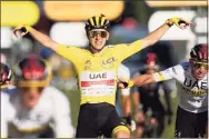  ?? Christophe Ena / Associated Press ?? Tour de France winner Tadej Pogacar celebrates as he crosses the finish line on Sunday in Paris.