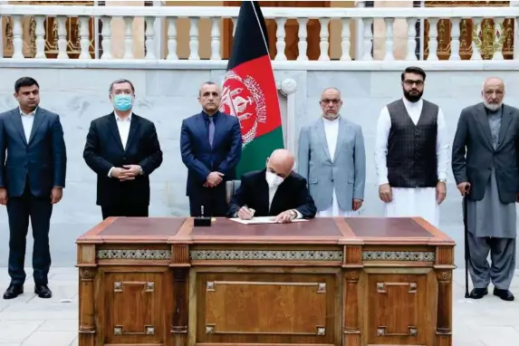  ??  ?? President Ashraf Ghani signs the decree in Kabul on Monday (EPA)