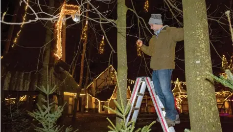  ?? Foto: Julian Leitenstor­fer ?? Heinrich Prinz von Bayern bei der Arbeit: Er hängt mit Lichterket­ten gefüllte Flaschen im Wald auf. Am Samstag eröffnet dieses Jahr wieder der Kaltenberg­er Weihnachts markt auf dem Schlossgel­ände – und ebenso viele weitere Christkind­lmärkte im Landkreis.